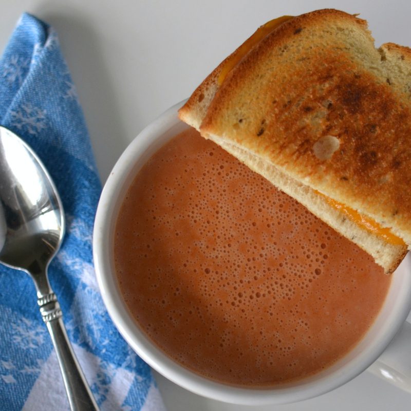 A warm bowl of tomato soup with a grilled cheese sandwich for an easy meal.